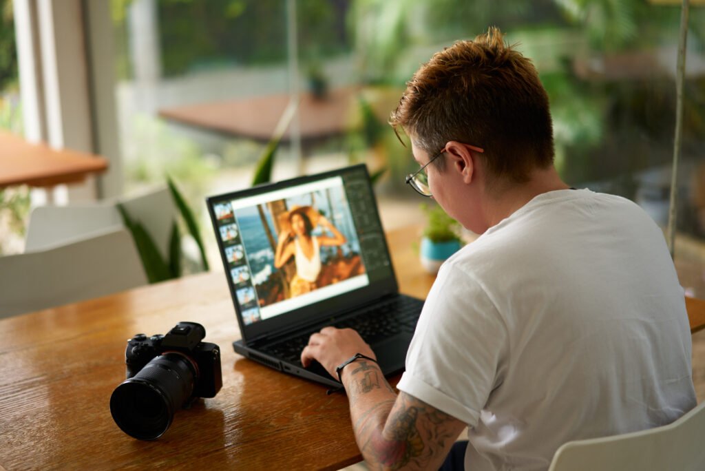 Pessoa de camisa branca usando um notebook para editar uma foto