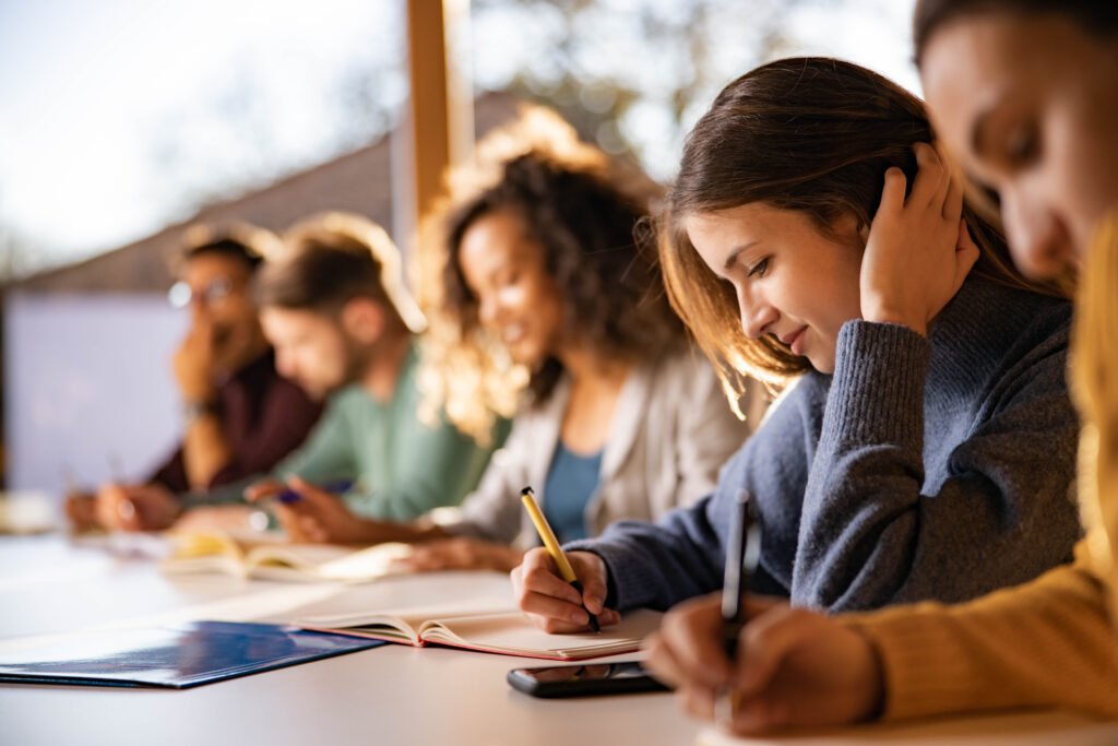 Estudante na mesa da sala de aula escrevendo em um caderno